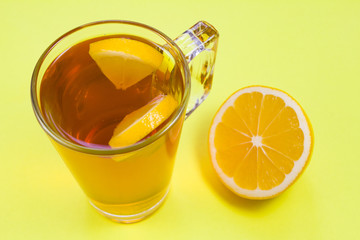 cup of tea with lemon on yellow background