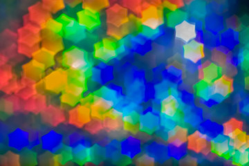 Fototapeta na wymiar Bokeh, abstract colorful background of defocused hexagon stars.