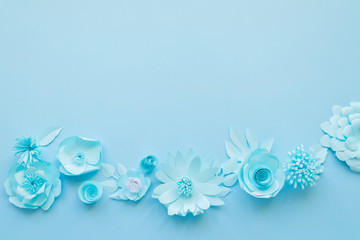 Fototapeta na wymiar Different blue paper flowers on blue background