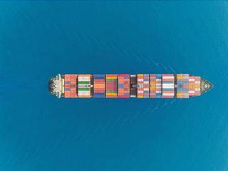 Aerial top view container ship at sea port and working crane bridge for loading container, logistic business, import export, shipping or transportation.