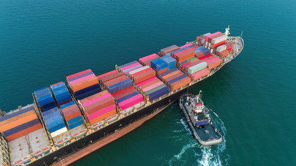 Aerial view Tug boat drag container ship at sea to sea port for logistics, import export, shipping or transportation.