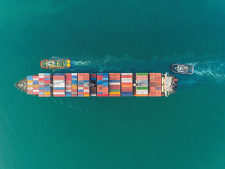 Aerial top view container ship at sea port and working crane bridge for loading container, logistic business, import export, shipping or transportation.