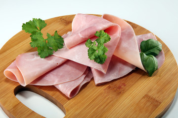 Sliced ham with parsley on table. Fresh prosciutto. Pork ham sliced.