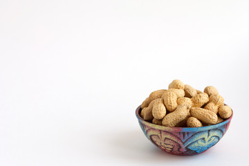 raw peanuts in shell on beautiful cup on white background, copy space