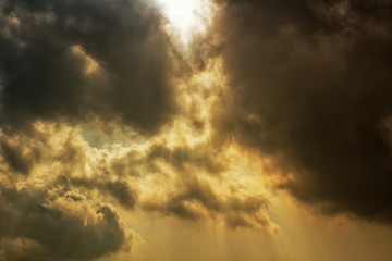 Naklejka na ściany i meble Rays of sunlight shining through dark storm clouds - dramatic apocalyptic effect