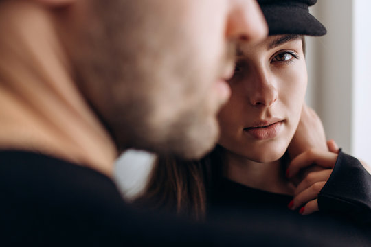 Two hipster models: a man and a woman in a blank black t-shirt, jeans and posing. in a black hat, cap, love, kisses