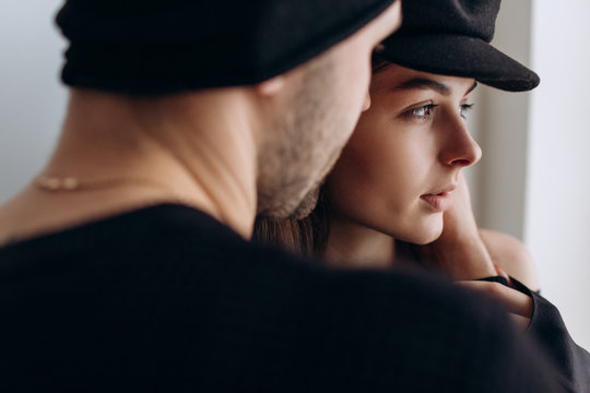 Two hipster models: a man and a woman in a blank black t-shirt, jeans and posing. in a black hat, cap, love, kisses