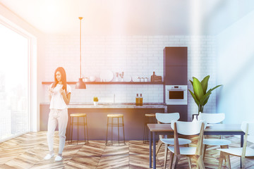 White loft kitchen, gray bar and table, woman