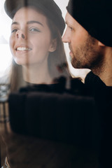 Two hipster models: a man and a woman in a blank black t-shirt, jeans and posing. in a black hat, cap, love, kisses