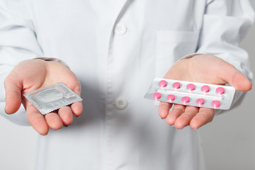 condoms and contraceptives in the hands of a doctor for safe sex