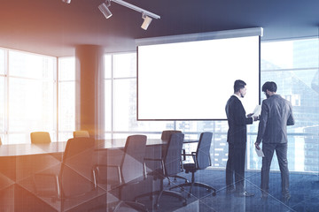 Office meeting room with beige chairs, people