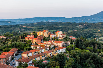 Chiusi village cityscape at sunrise in Umbria Italy with streets and rooftop houses on mountain countryside and rolling hills