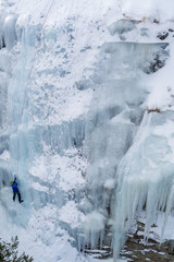 Ice climbing the North Greece, man climbing frozen waterfall.