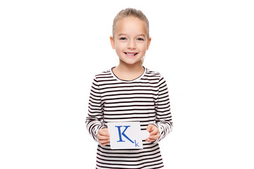 Young girl holding a card with letter K. Speech therapy concept on white background. Correct pronounciation and articulation at preschool age. - obrazy, fototapety, plakaty