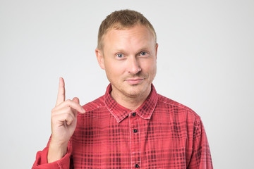 Fototapeta premium Casual man pointing his finger up having idea.