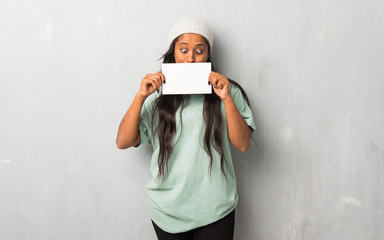 Young afro american woman on textured background holding a placard for insert a concept