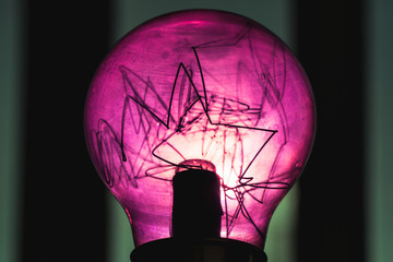 Decorative purple tungsten lamp over dark