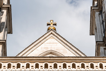 Obraz premium London, United Kingdom famous Westminster Abbey facade exterior with nobody closeup of tower roof gold, golden cross isolated against sky