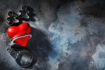 Forbidden love. Red heart in handcuffs with copy space, top view