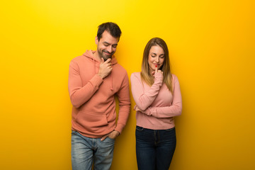 Obraz premium Group of two people on yellow background looking down with the hand on the chin