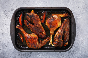 Baked duck with oranges in a baking tray on the table