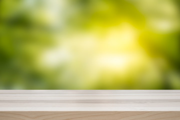 Empty table top for product display montage. Green spring nature concept with blurred background.