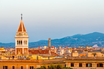 Historic Italian town of Rome, Italy cityscape skyline with high angle view of vibrant orange architecture old buildings tower during sunset evening night