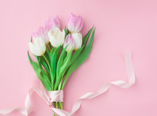 Bouquet of tulips on a pink pastel background. Wonderful spring breakfast on Mother's Day or Women. Flat lay. View top. Selective focus.