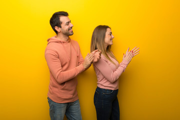 Obraz premium Group of two people on yellow background applauding after presentation in a conference