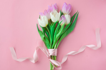 Bouquet of tulips on a pink pastel background. Wonderful spring breakfast on Mother's Day or Women. Flat lay. View top. Selective focus.