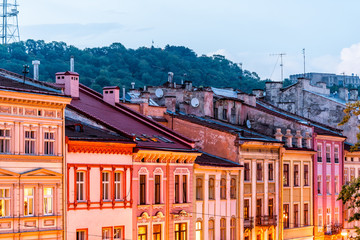 Historic Lviv, Ukraine cityscape exterior with colorful architecture buildings in old town market square in evening night illuminated multicolor houses