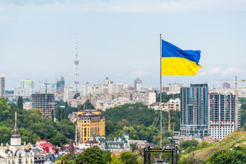 Kyiv, Ukraine Cityscape skyline of Kiev and Ukrainian flag waving in the wind during summer in...