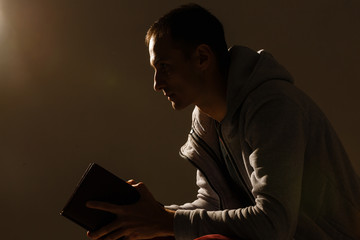 Handsome man sit prayer on black background. His hands are praying for God's blessings.