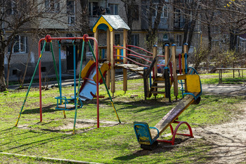 an old playground stands in the courtyard of a residential building