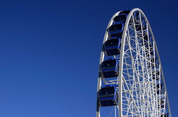 Ferris wheel against a bright blue sky
