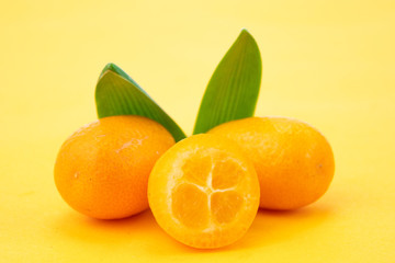 Ripe kumquats on yellow background
