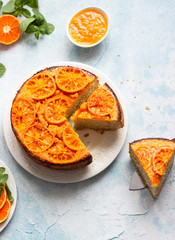 Upside down tangerine cake on a sky blue stone or concrete background.