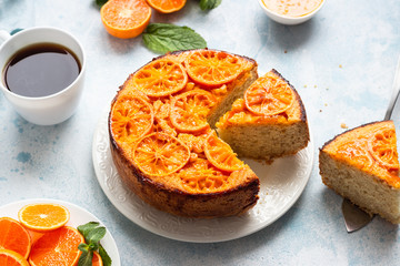 Upside down tangerine cake on a sky blue stone or concrete background.