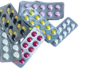 Vitamins and tablets blister pack on a white background, close-up.