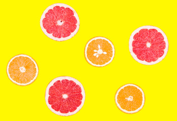 Fresh half cut grapefruit and orange isolated on yellow background. Close up view. Fruit concept. Healthy lifestyle concept.