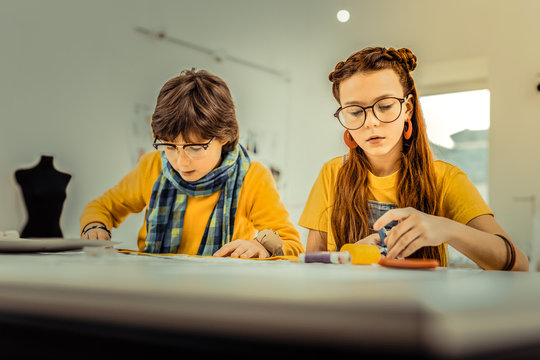 Children attending design school using colorful threads