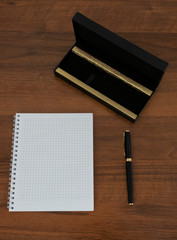 notebook and pen on wooden table