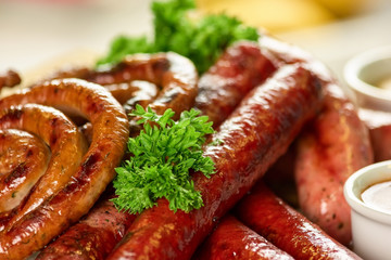 Pile of straight and coil sausages with parsley closeup. Straight and coil sausages with garnish.