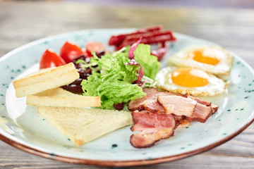 Sliced white bread, ham and lettuce salad closeup. White plate with food.