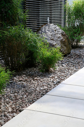 "Moderner Gartenbau: Gehweg aus Betonplatten und Grünpflanzen im