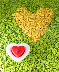 Yellow stone heart with burning red candle

