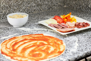 Ingredients for salami pizza. Pizza is ready for cooking. Pizza basis with ketchup, salami,...