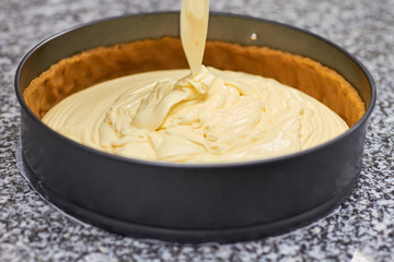 Close up batter pouring. Black pan with batter.