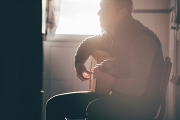 Backlight of man playing Spanish guitar.