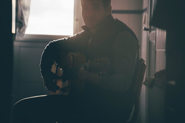 Backlight of man playing Spanish guitar.